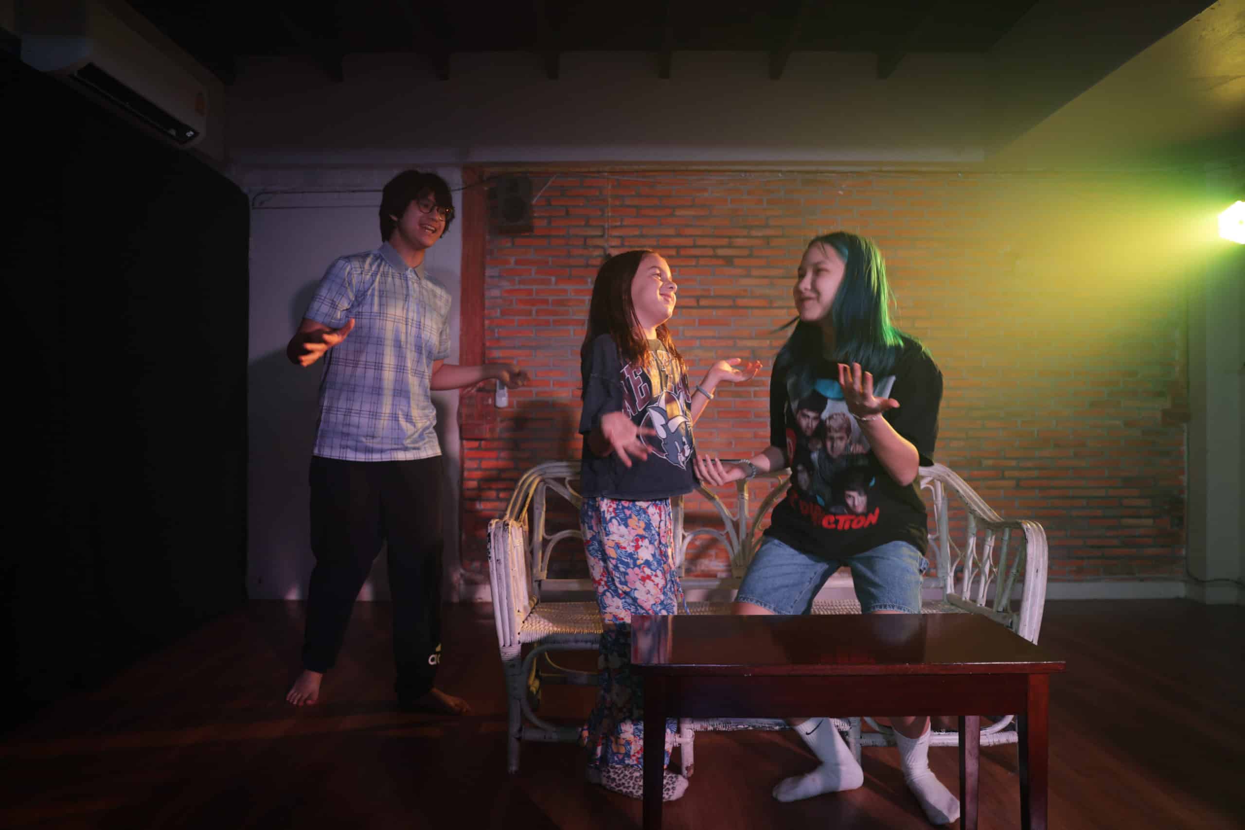 roup of teenagers laughing and rehearsing a scene in a vibrant Bangkok classroom